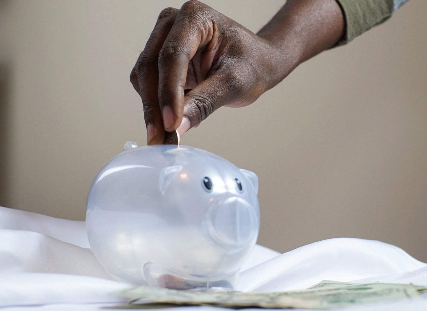 Woman dropping change into a piggy bank for saving towards a new Chevrolet vehicle.