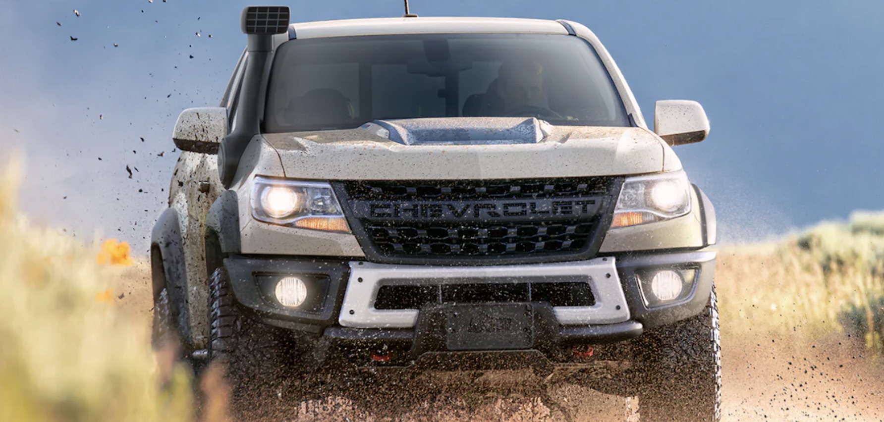 Chevrolet Colorado driving through the mud while sporting a snorkel.