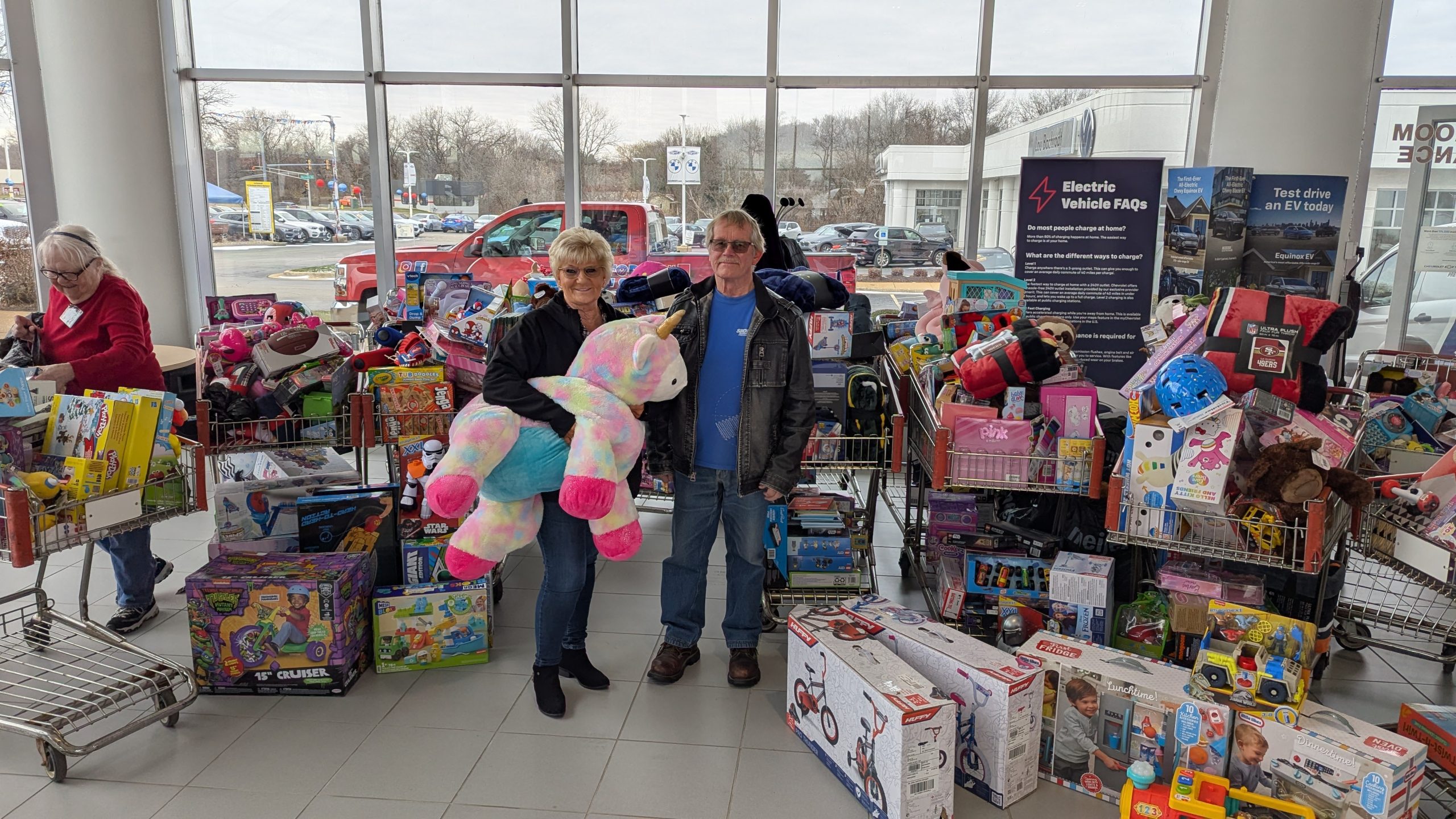 Two Bachrodt On State employees standing in front of the toy drive donations