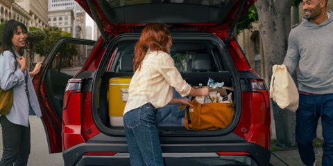 A woman packing the trunk of a new red 2026 Chevy Equinox. | Lou Bachrodt Auto Mall in Rockford IL